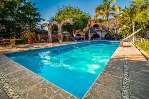 a large swimming pool with blue water at Hotel San Jose Purua in Vidalrstn