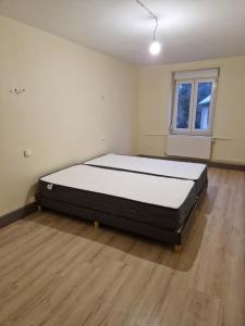 a large bed in a room with a wooden floor at La ferme 1313 jusqu'à 8 personnes in Cirey-sur-Vezouze