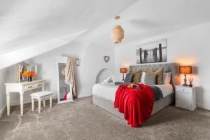 ein Schlafzimmer mit einem Bett mit einer roten Decke darauf in der Unterkunft The Postmaster's Retreat in Mickleton