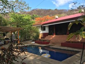 a house with a swimming pool in front of it at Casa Avi Fauna Nature Guesthouse Y Casa AlmaCalma in Ocotal