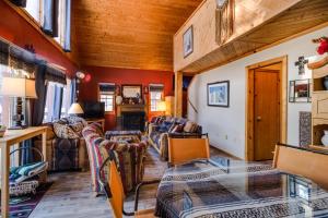 a living room filled with furniture and a wooden ceiling at Angel Fire Cabin in Angel Fire