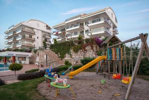 un parque infantil frente a un edificio de apartamentos en Sunset Beach Vip 2 Residences, en Alanya