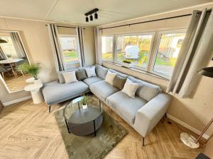 a living room with a couch and a table at Miarlo Lodge Derwent Haven Lakeland in Grange Over Sands