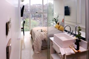 een badkamer met een bed, een wastafel en een spiegel bij Niyat Urban Hotel in Resistencia