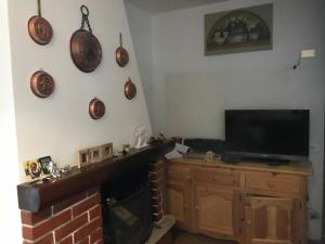 a living room with a fireplace and a flat screen tv at Piccolo chalet in Aprica