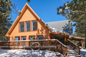 a house with a deck in the snow at Angel Fire Cabin in Angel Fire