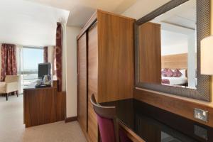 a hotel room with a mirror and a bed at Waterfront Southport Hotel in Southport