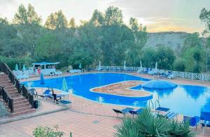 a large swimming pool with chairs and umbrellas at Iside Apartment - piscina - vista mare in Casa Donato