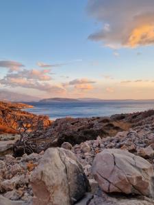 a group of rocks on a beach with the ocean at Eola Leisure Rooms in Stara Baška
