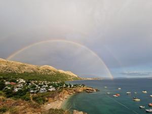 a rainbow over a harbor with boats in the water at Eola Leisure Rooms in Stara Baška