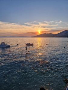 a man standing in the water at sunset at Eola Leisure Rooms in Stara Baška