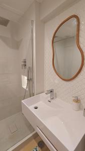 Un baño blanco con lavabo y espejo. en Beach4you - Sesimbra, en Sesimbra 29 fotos más