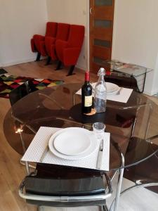 a glass table with two plates and a bottle of wine at beau studio centre ville in Bordeaux