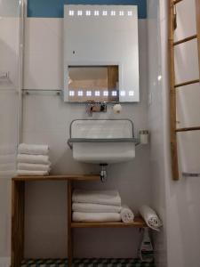 uma casa de banho com lavatório, espelho e toalhas em beau studio centre ville em Bordeaux