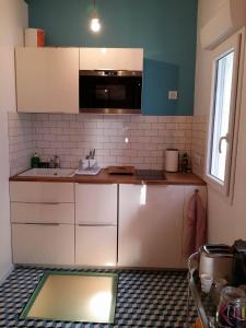 a kitchen with white cabinets and a sink and a window at beau studio centre ville in Bordeaux