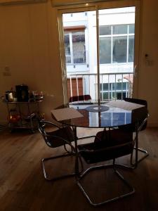 una mesa y sillas en una habitación con balcón en beau studio centre ville, en Burdeos