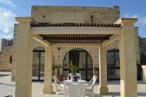 アーブにあるJenkins Holiday Farmhouseの石造りの建物の下にテーブルと椅子付きのパティオ