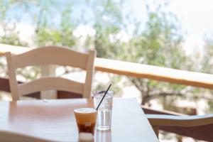 a cup of coffee sitting on a table with a drink at CORAL in Parga