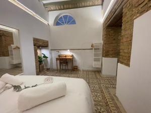 a bedroom with a white bed and a table at La casa grande in Carmona