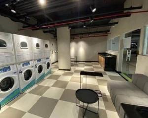 a laundry room with washing machines and a chair at Apartamento em Resort, Brasília in Brasilia