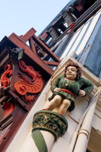 une statue d'un homme sur le côté d'un bâtiment dans l'établissement La Maison Normande, à Trouville-sur-Mer