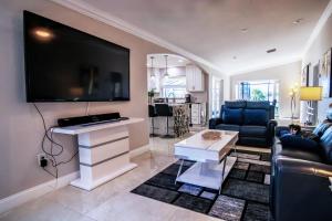 sala de estar con TV de pantalla plana grande en la pared en Lakefront and Pool 4bed Orlando House Near Downtown 20 minutes from Attractions, en Orlando