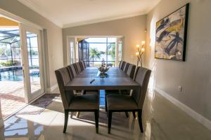 Un comedor con mesa y sillas de madera. en Lakefront and Pool 4bed Orlando House Near Downtown 20 minutes from Attractions, en Orlando