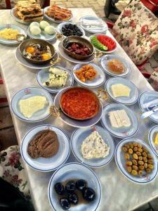 a table with many plates of food on it at Grand Ayhan Hotel Kuşadası in Kusadası