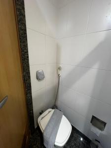 Un baño con inodoro en una habitación con azulejos blancos. en Apto Incrível no Centro do Rio, en Río de Janeiro 3 fotos más