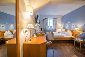 a hotel room with a bed and a desk in it at Goldener Adler Oberried - Hotel & Appartements in Oberried