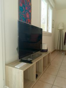 a television on a wooden stand in a room at Appartement-maison avec jardin in Uffheim