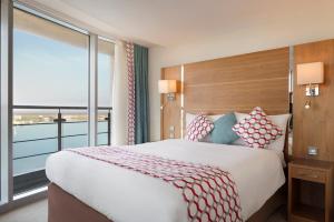 a bedroom with a large bed with a large window at Waterfront Southport Hotel in Southport +37 photos