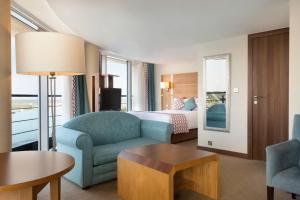 a hotel room with a bed and a couch and a table at Waterfront Southport Hotel in Southport