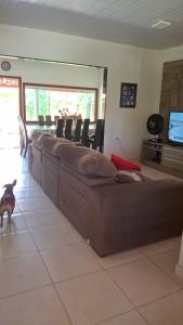 a large couch in a living room with a dog at Casa de Praia para Carnaval in Prado