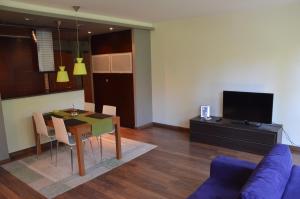 uma sala de estar com uma mesa e um sofá azul em Apartament Agata em Świnoujście