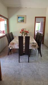 a dining room table with chairs and flowers on it at Casa de Praia para Carnaval in Prado
