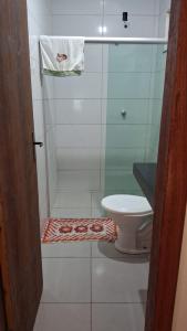 a bathroom with a shower with a toilet and a towel at Casa de Praia para Carnaval in Prado +8 photos