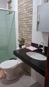 a bathroom with a toilet and a sink at Casa de Praia para Carnaval in Prado