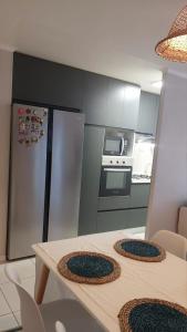 a kitchen with a table and a stainless steel refrigerator at CasaNativa 7Sur in Curicó