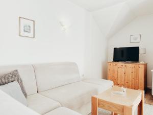 a living room with a white couch and a table at Alpenquartier Montafon in Tschagguns