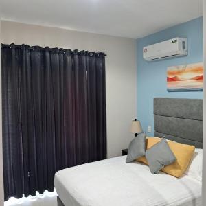 a bedroom with a bed with a black curtain at Flamingo Villa in Boca Paraiso in Boca Chica +14 photos