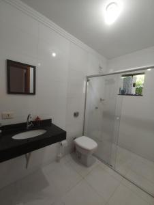 a bathroom with a shower and a toilet and a sink at Sobrado para show rural in Cascavel