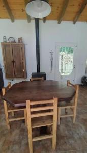 einen Holztisch und Stühle in einem Zimmer mit einem Herd in der Unterkunft La candelaria in Villa Ciudad Parque + 3 Fotos