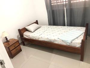 a bedroom with a bed and a night stand at Apartamento Da Costa in Mão para Trás