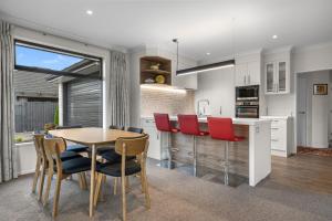a kitchen and dining room with a table and chairs at Sauvignon Place - Blenheim Holiday Home in Blenheim