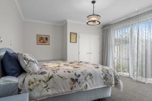 a bedroom with a bed and a large window at Sauvignon Place - Blenheim Holiday Home in Blenheim