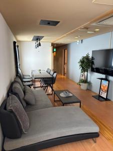 a living room with a couch and a table at Mountain Gate FURANO in Kami-furano