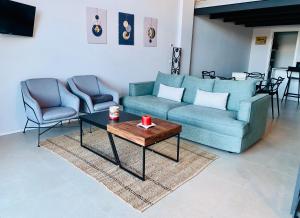 a living room with a couch and two chairs and a table at Panorama Loft Apartments in Stresa