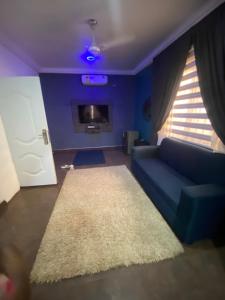 - un salon avec un canapé bleu et un tapis blanc dans l'établissement Love at first sight, à Apenkwa
