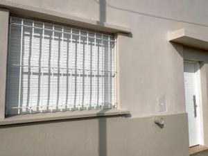 a window with blinds on it in a room at Departamento Azul in Azul +1 photo